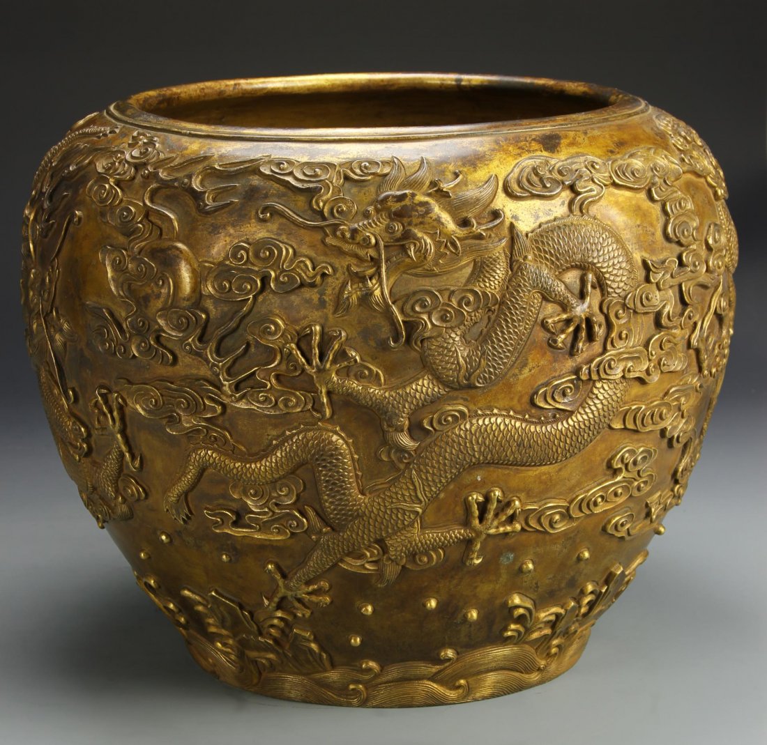 Chinese Gilt-Bronze Dragon Jardinière: China, Qing period, finely cast with relief of two matching pairs of dragons and a flaming pearl, cast mark on base. Diameter 13 3/4 in. Provenance: Formerly in the collection of Mrs. Gloria O'Hara, V