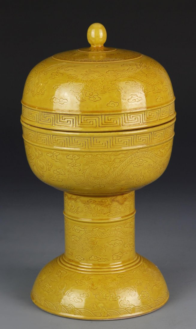 Chinese Tall Covered Vesel: China, 19th C., yellow glazed tall vessel with cover, overall incised with dragons amidst clouds, two bands of hui patterns on rims, Dao Guang mark on base. Dimensions: 11 1/2 in. x 6 in. (note: one m