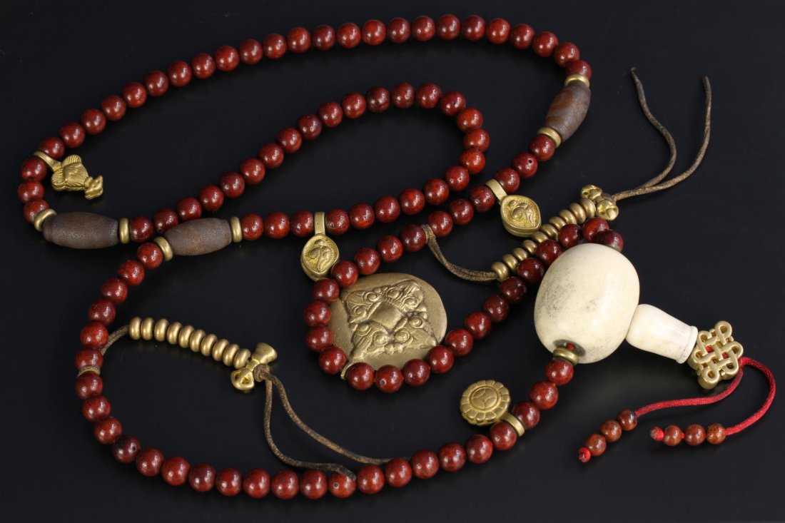 Tibetan Linden Prayer Beads: Tibet, 19th C., a set of prayer beads include of 108 round linden seed beads spaced with gilt-metal Buddhist symbols. Length 46 in.
