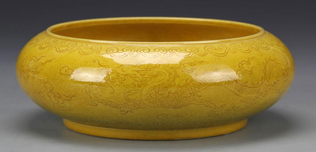Chinese Yellow Glazed Brush Washer: China, 18/19th C., yellow glazed brush washer with incised dragon motifs on side, and Kangxi mark on base. Height 2 1/2 in., Diameter 6 1/4 in.