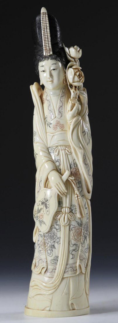 Japanese Carved Ivory Figure: Japanese, 19th C., figure of a woman holding a mirror in her hand, and flowers in the other, she has dark-colored hair and beautifully painted flowers on her garment, marking on base. Height 12 in., W