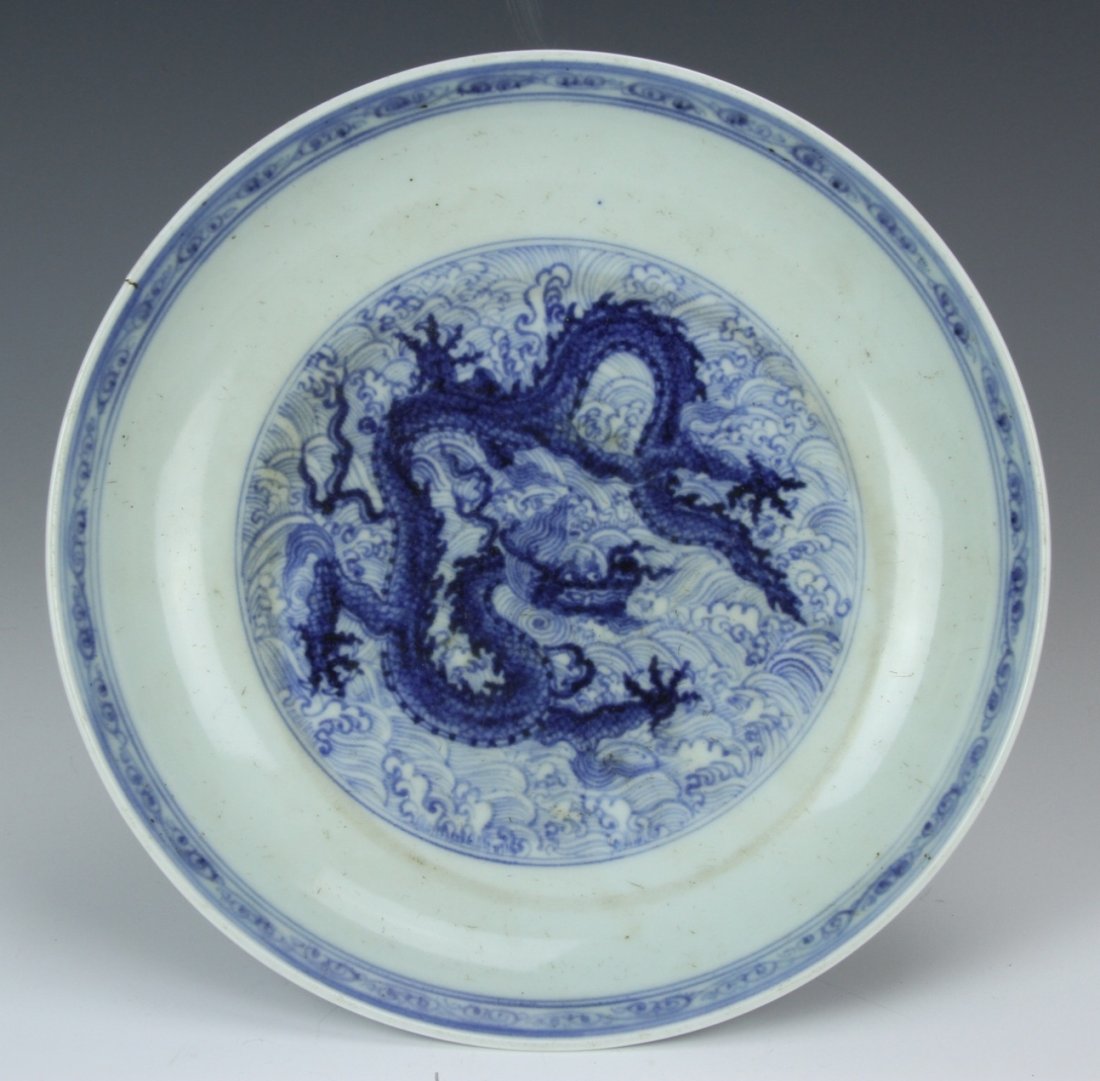 Chinese Blue and White Dragon Plate: China, 19th C., blue and white dragon plate, with a band of auspicious patterning around the inner rim, and a serpentine dragon in the center medallion, Xuande mark, and a minor firing flaw on the rim