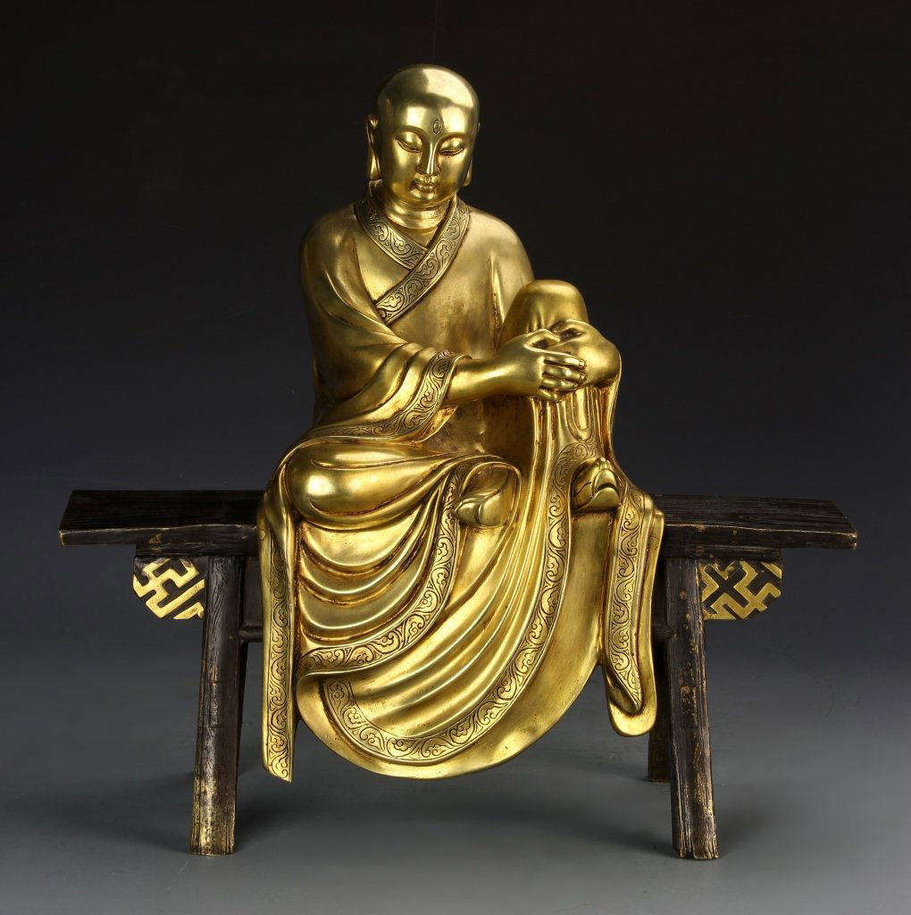 Chinese Buddha on Bench: China, Buddha figure seated on a bench in a casual position, with flowing robes with decorated trim, and a serene expression on the face. Height 17 in.