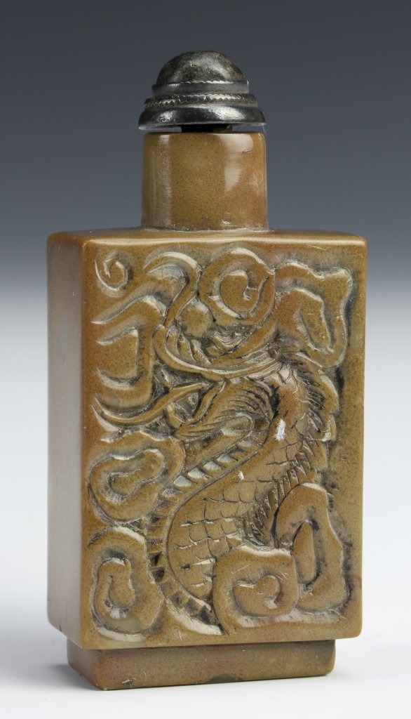 Chinese Duan Ink Stone Snuff Bottle: China, 19th C., duan ink stone snuff bottle, of a rectangular form, carved with the image of a dragon moving from one side of the bottle to the other, with stopper, with mark. Length 2 3/4 in.