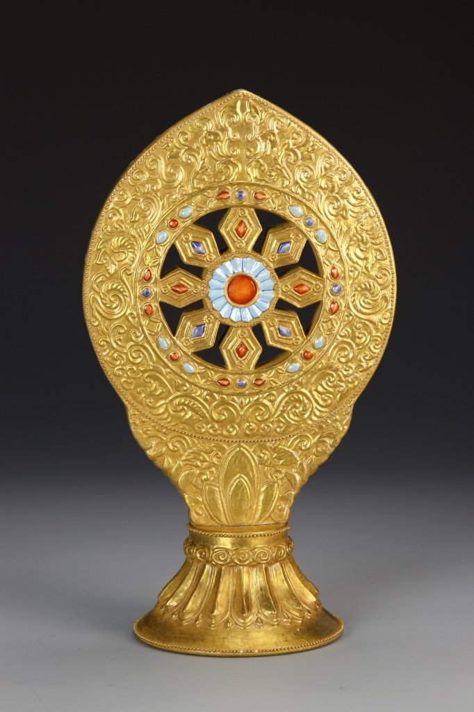 Chinese Gilt Glazed Buddhist Wheel of Teaching: China, gilt glazed Buddhist wheel of teaching, decorated with scrolling floral motifs, and on placed on a lotus base, Qianlong mark. Height 11 in.