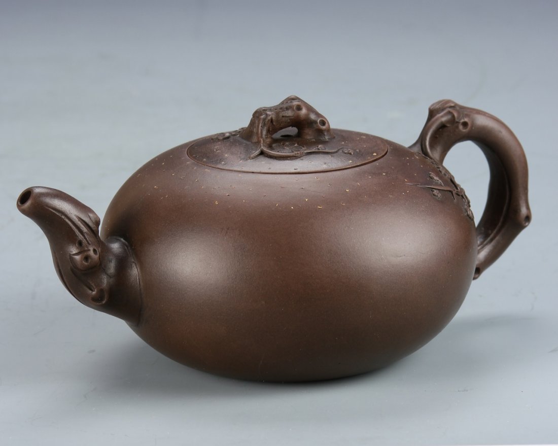 Chinese Yixing Teapot: China, Yixing teapot, in a rounded form, decorated in relief with natural forms, signature on base attributed to Nang Yan Xing. Width 7 1/2 in., Height 3 in.