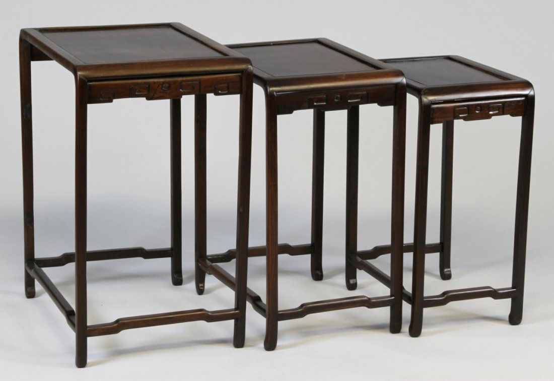 Chinese Huanghuali Wood Nesting Tables: China, 19th C., a set of three Huanghuali wood nesting tables, finely carved and constructed, with stretchers and decorative side brackets. Width 20 in., Diameter 14 1/2 in., Height 25 in.