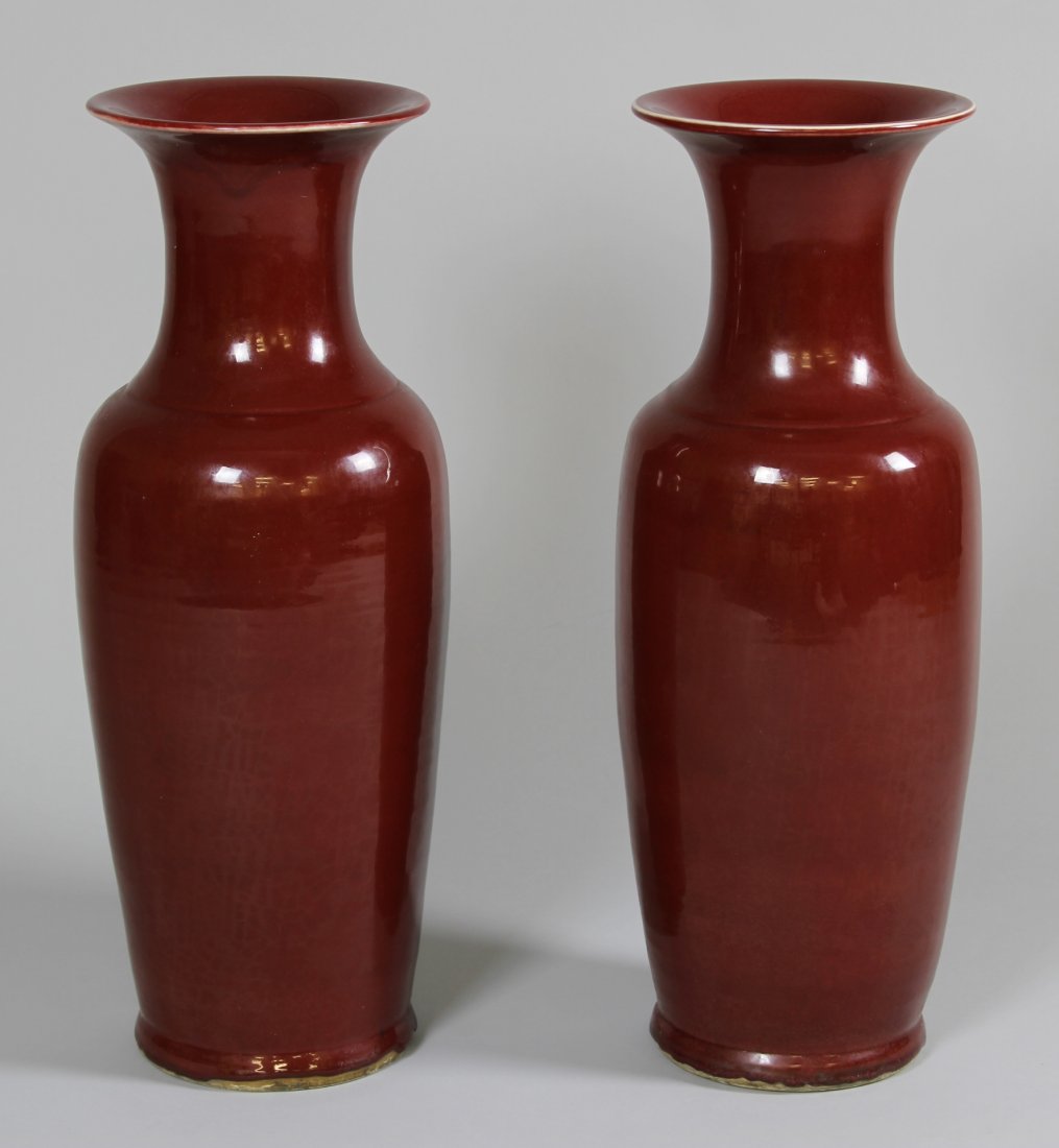 Pair of Chinese Red Glazed Vases: China, pair of tall deep-red glazed vases, with flared rims and slightly footed bases, marking on each base. Height 22 1/2 in., Width 7 1/4 in.