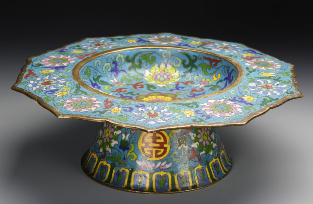 Chinese Cloisonne Plate: China, star burst shaped cloisonne plate on high footed base, gilt edging throughout, floral patterns in bright colors against blue ground. Width: 11 in., Height: 4 in.