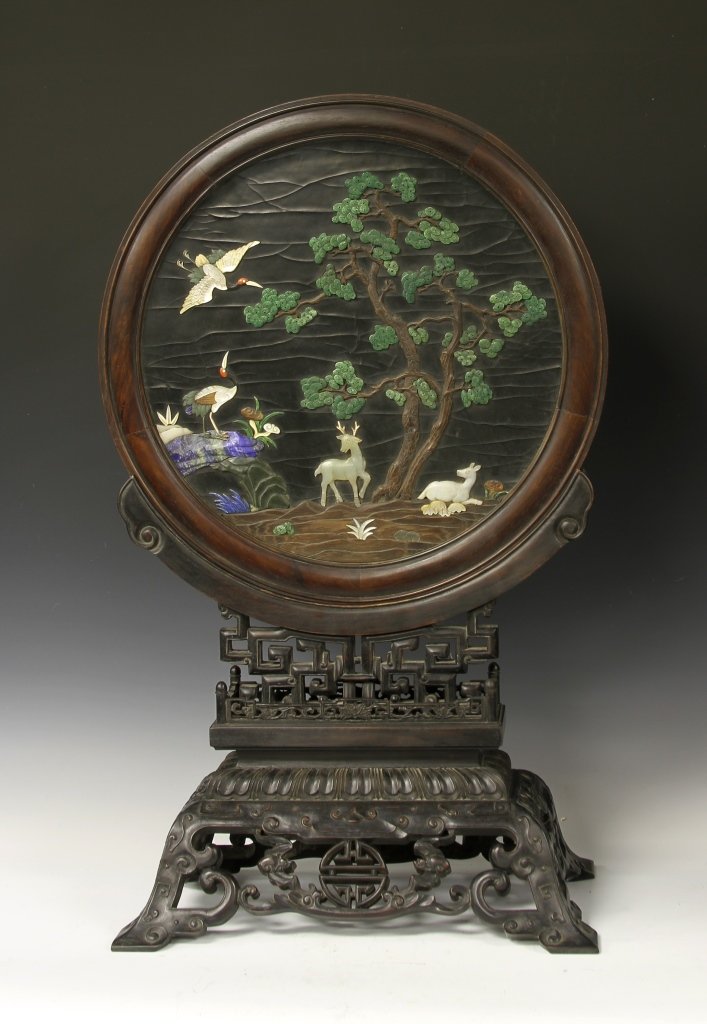 Chinese Table Screen: China, table screen, expertly carved, two sided round screen decorated with animals and birds under a tree, the other with gilt painting of mountains by the river, placed on a tiered and highly carved