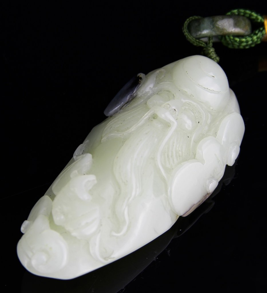 Chinese Carved Jade Shou Lao Figure: China, white jade stone with one grey jade piece, connected to a green cord with grey jade ring, expertly carved into a Shou Lao figure, with a long beard and pleasant expression. Height 2 1/2 in.