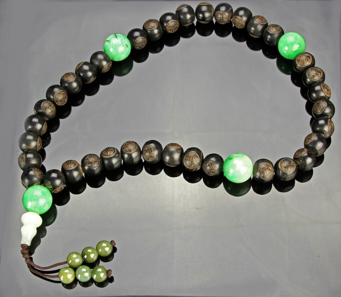 Chinese Carved Jadeite and Wood Necklace: China, 19th C., wood and Jadeite necklace, smooth round wooden beads, divided by a green bead in divisions of nine, with thread and smaller beaded tassel. Length Approximately 20 in.