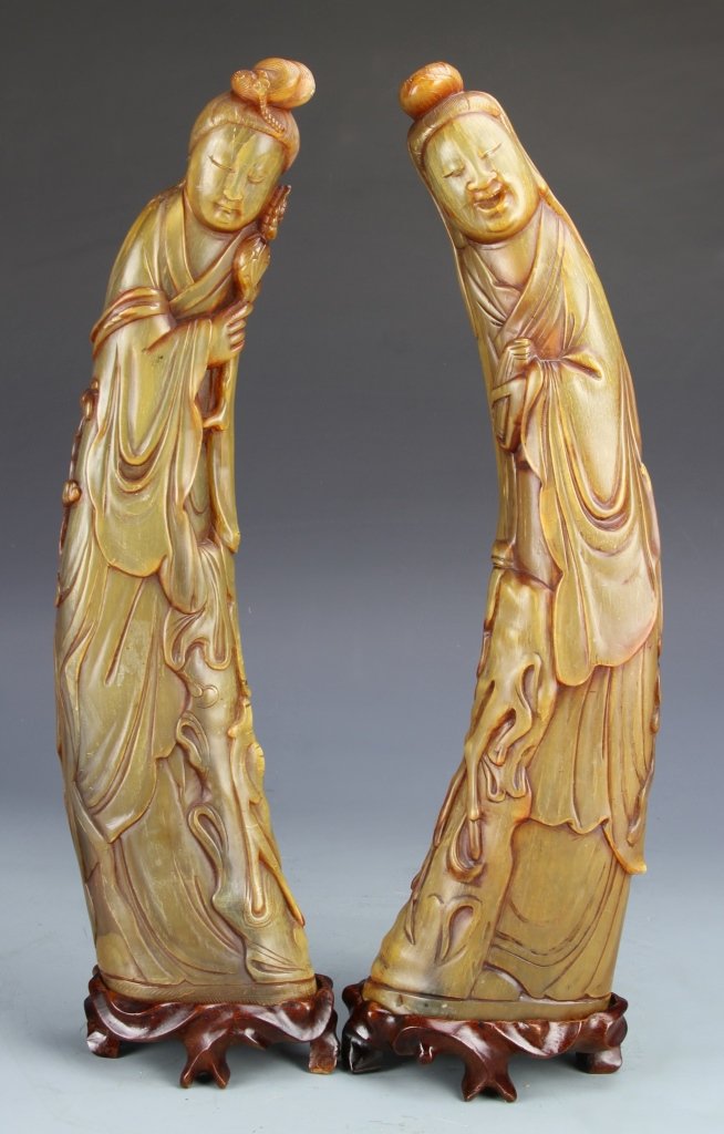 Pair of Chinese Horn Cups: China, pair of horn cups, each cup carved into two elaborately robed figures, both rendered in a delicate fashion, with great detail on the clothing and faces, together with intricately carved bases. 