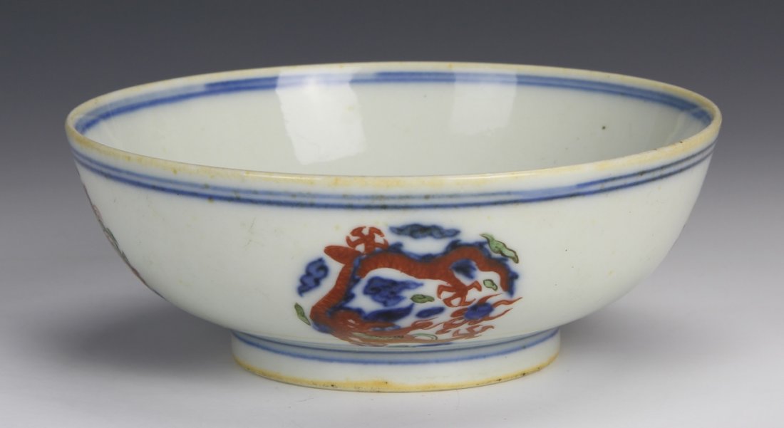 Chinese Wucai Bowl: China, footed Wucai bowl, with painted medallions, featuring colorful, serpentine, fire-breathing dragons, blue lines along rim and base, Wanli mark on base. Height 2 in., Diameter 5 1/8 in.