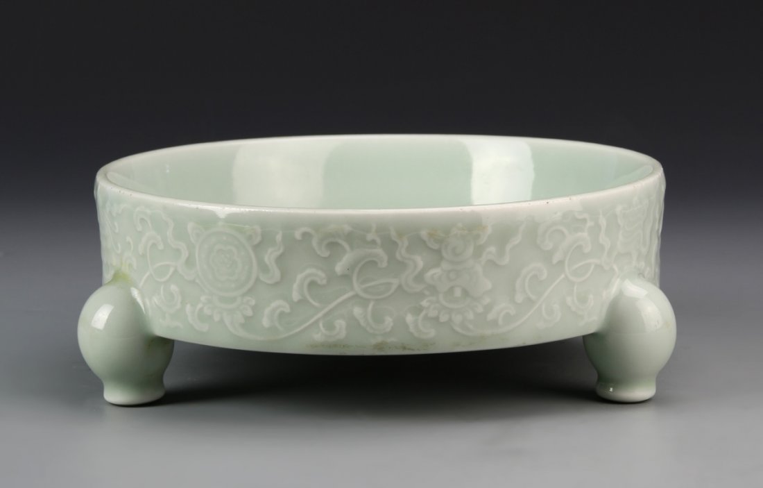 Chinese Antique Celadon Glazed Tripod Brush Washer: China, antique celadon glazed tripod brush washer, with three rounded feet, and white floral motif, with Yongzheng mark. Height 3 in., Diameter 7 3/4 in.