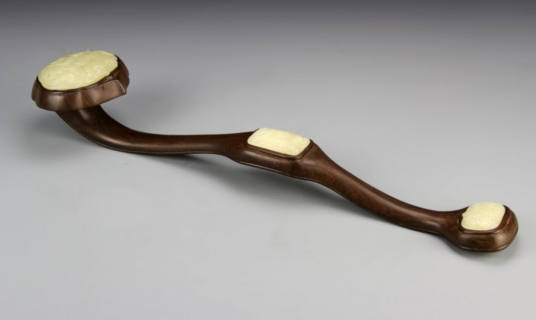Chinese Wood and Jade Ruyi Scepter: China, 20th C., wood ruyi scepter with three jade inlays, carved with a natural motif, with box. Length 19 in.