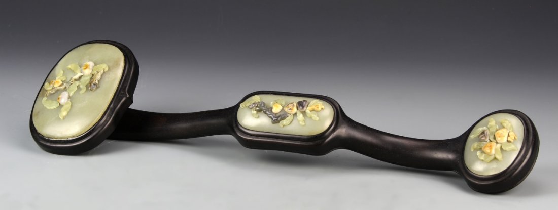 Chinese Zitan and Jade Ruyi Scepter: China, 19th C., Zitan Ruyi scepter with three inlays of jade panels,expertly carved with inlays of jade, ovoid in form, featuring floral motif decorated by natural striations in rock. Length 21 in., W