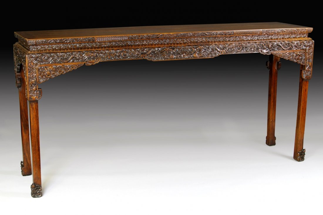 Chinese Huanghuali Altar Table: China,19th C., a large and magnificent Huanghuali altar table, intricately carved in relief with dragon motifs. Height 33 3/8 in.; Width 68 3/4 in.; Depth 15 7/8 in. Provenance: Estate of Santa Barbar