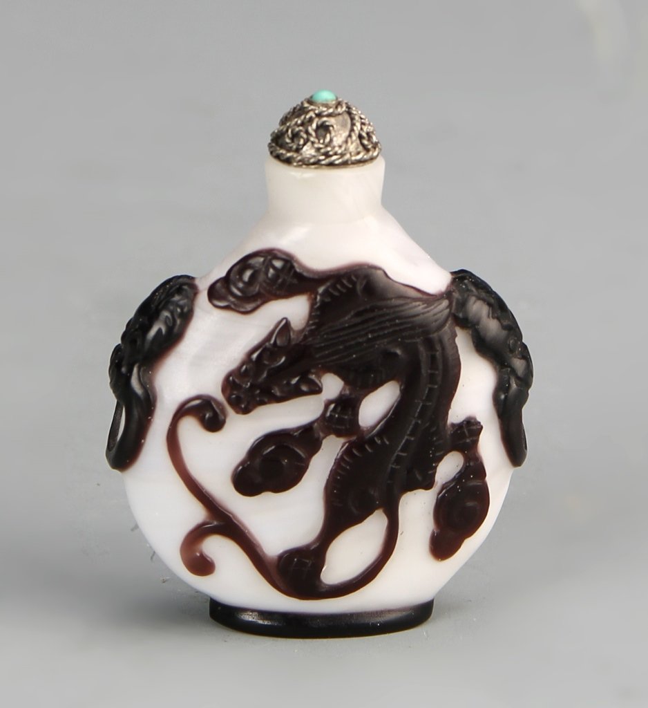Chinese Peking Glass Snuff Bottle: China, Peking glass snuff bottle, in a flattened circular form, with an overlay of brown glass, depicting mythical creatures, with stopper. Height 2 in.