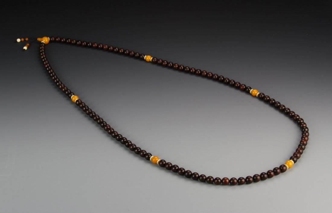 Chinese Black Chen Xiang Buddhist Prayer Beads: China, rare black Chen Xiang Buddhist prayer beads, consisting of 108 black Chenxiang beads, interspersed with larger orange beads. Length 63 in., Diameter 1.6 cm. Provenance: Estate of Chris Kain, De