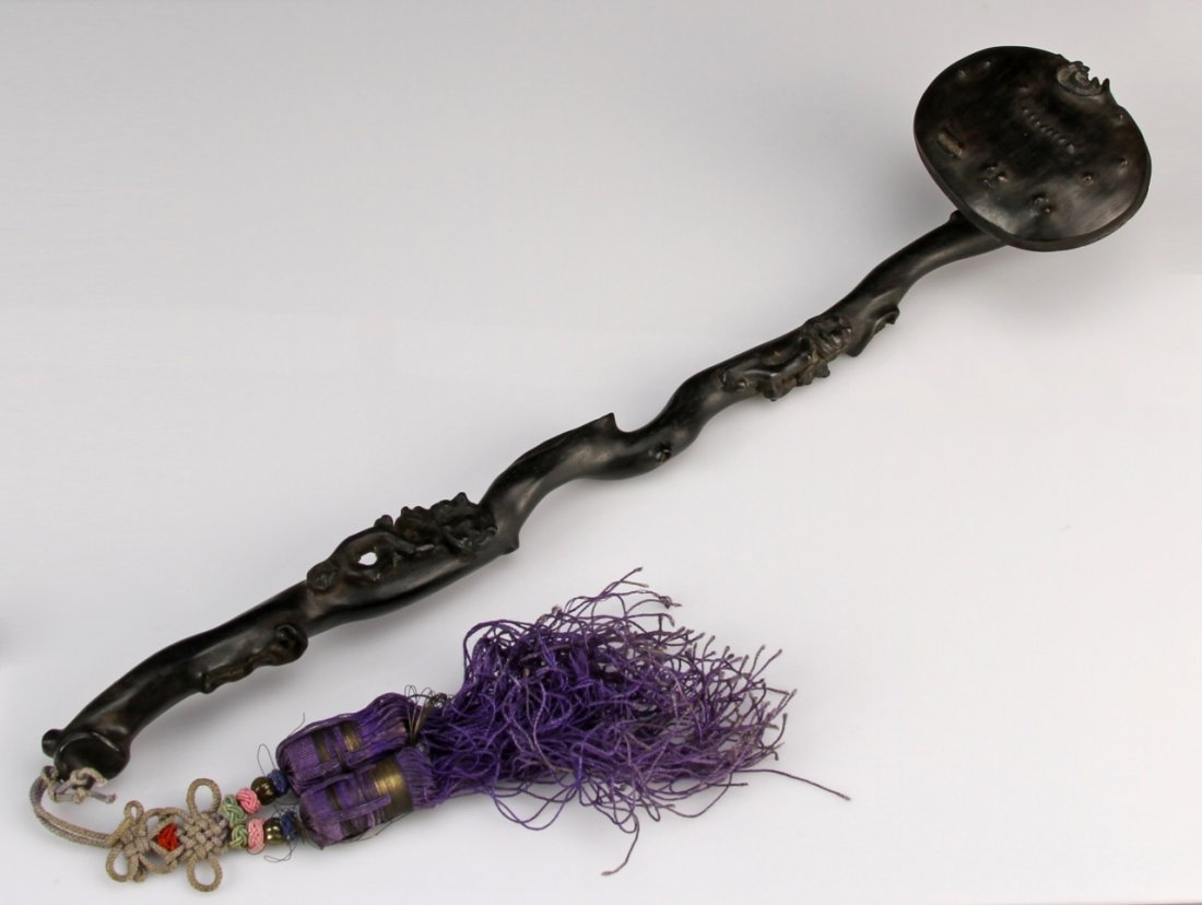 Chinese Zitan Ruyi Scepter With Tassel: China, 19th C., Zitan Ruyi scepter, the shaft carved to show the natural texture of the wood and with a smooth finish, the head with some decorations, attached to a purple tassel. Height 12 in.