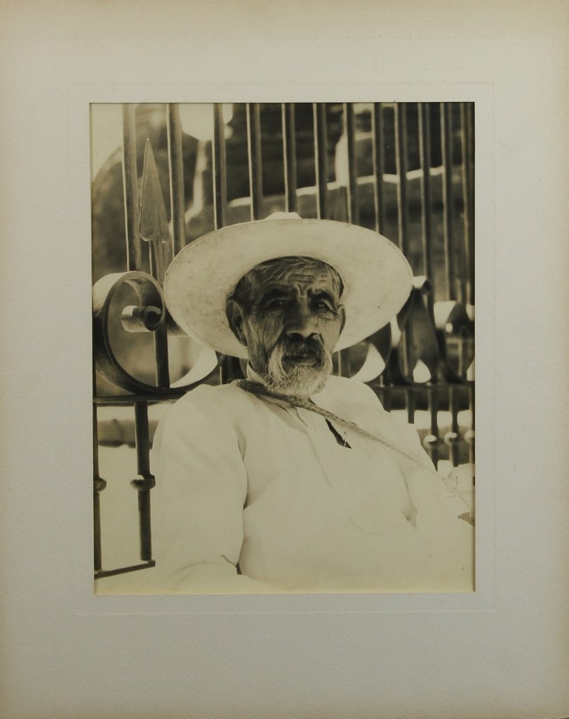 Large Format Photo: Large format original photo of Mexican man, in a seated position, showing from the shoulders up, wearing a large white hat, with a fence in the background. Height 10 1/2in., Width 13 1/2in.