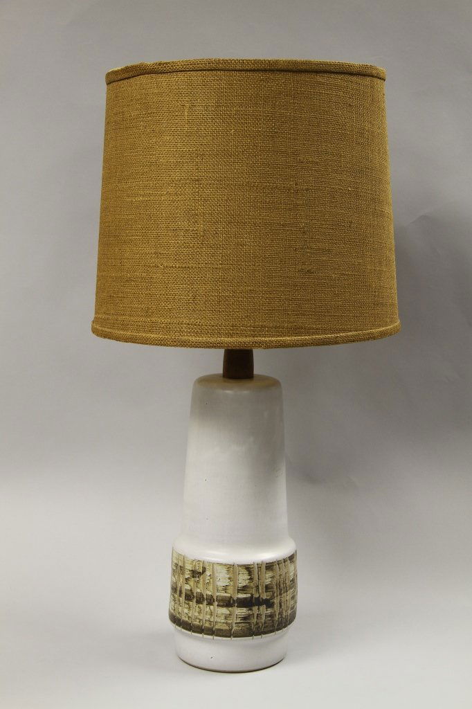 Mid Century "Martz" Lamp: Mid-century "Martz" lamp, cylindrical body, white in color, decorated rim around body, canvas shade in a brown hue. Height 18 in.