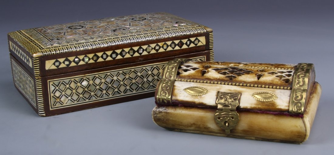 One Bone and One Wood Jewelry Box: A pair of jewelry boxes, one jewelry box made of wood with geometric inlays, the other made from bone with metal clasps and a square rounded edge. Length 7 in., Width 4 in., Height 2 1/4 in.