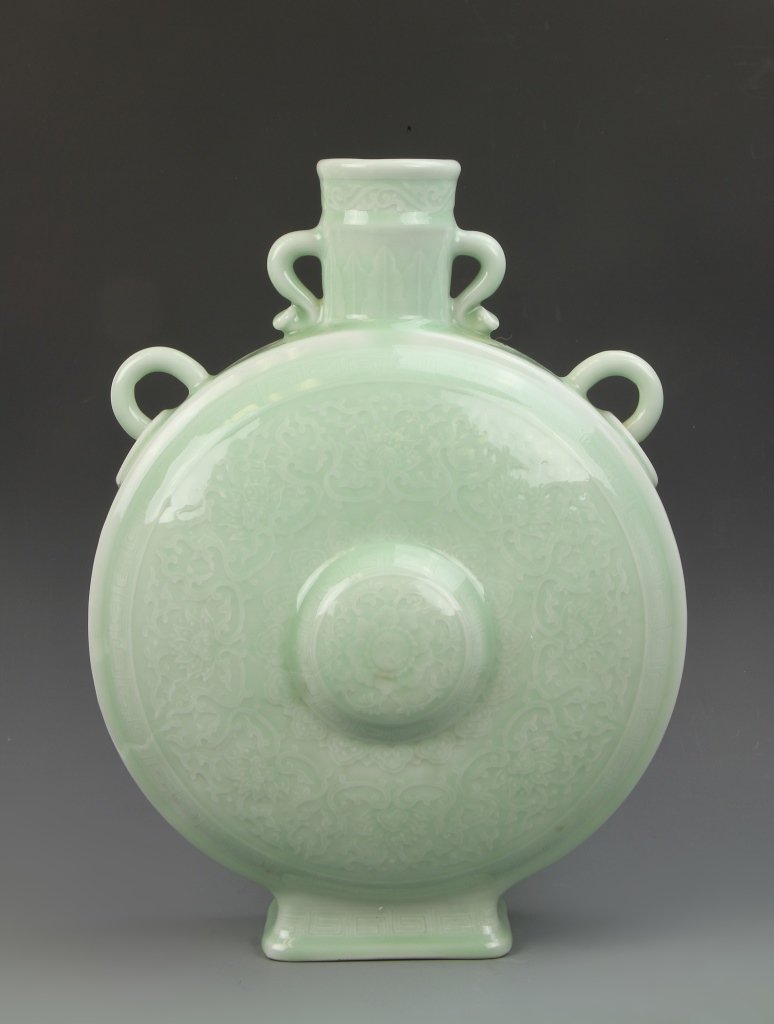 Chinese Celadon Moon Flask Vase: China, celadon moon flask vase, small handles at base of neck loops on either shoulder, relief carving of floral motif and line patterns, light green even glaze, Qianlong mark. Height 16 in.