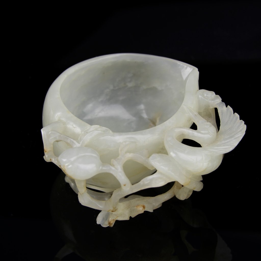 Chinese Jade Brush Washer: China, 18th C., jade brush washer, circular in form, attached floral and bird details, white hue, striations in the stone. Height 1 1/4 in., Length 3 in. Provenance: From the private collection of Mrs