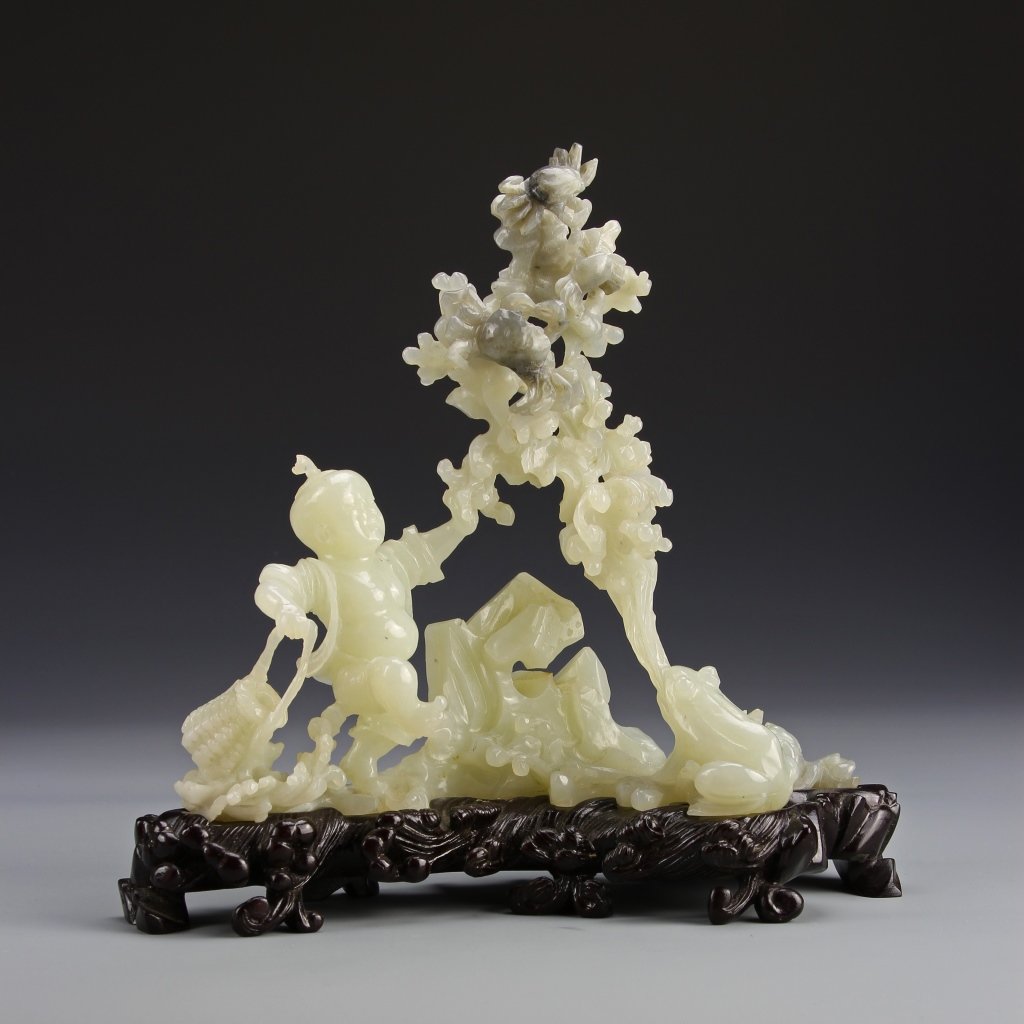 Chinese Jade Luihai: China, jade Luihai on wooden stand, light green carved form of a tree with a small boy holding a woven basket on one side and a large frog on the other. Height 8 1/2 in. Provenance: From the private c
