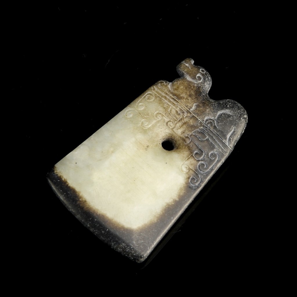 Chinese Jade Pendant: China, Han Dynasty, jade pendant, rectangular in form with mythical figure seated at top, key fret pattern below figure, brown and white marbled hue. Height 2 5/8 in.