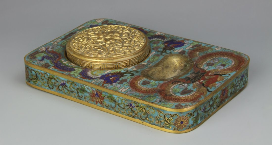 Chinese Cloisonne Ink Pad: China, 19th C., cloisonne ink pad with a cover, rectangular in form, rounded corners, gilded edging, painted dragon and floral motifs, Qianlong mark. Length 7 in., Width 4 3/4 in., Height 1 7/8 in.