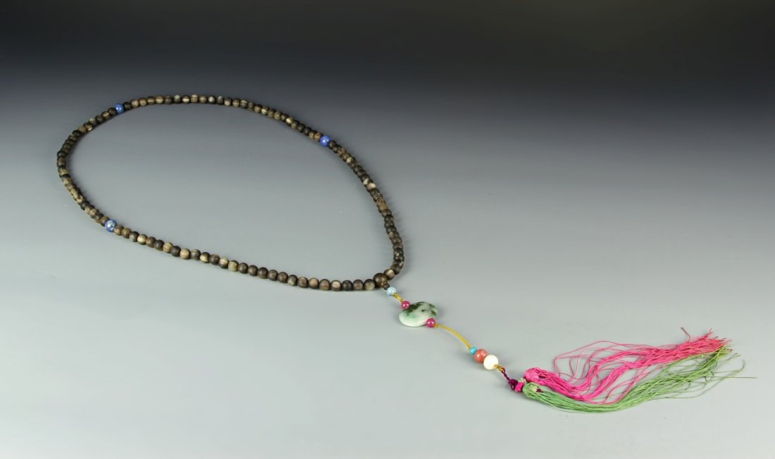 Chinese Horn Buddhist Prayer Beads: China, Qing Dynasty, horn Buddhist prayer beads, comprised of 108 spherical natural horn beads, spaced with lapis lazuli, the center bead suspending a jadeite pendant with strand of tourmaline and pea