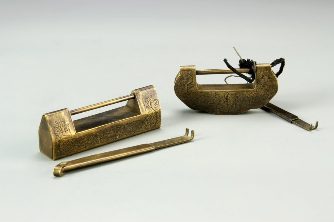 Two Chinese Brass Locks: China, two brass locks, one with fish and floral motifs, the other with figures in a landscape, both with matching keys, and patina. Largest Length 3 1/4 in.