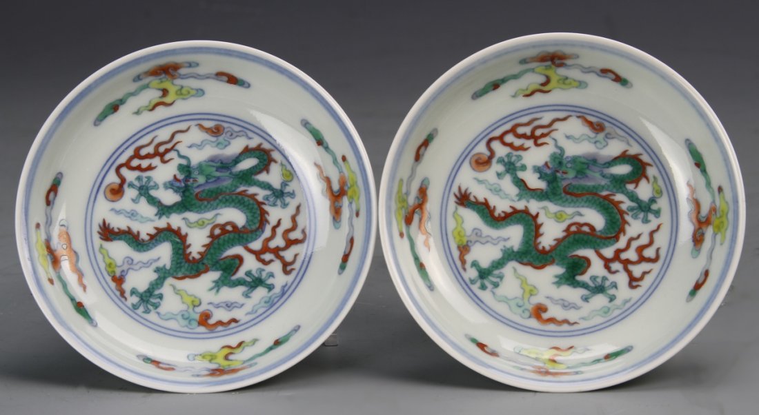 Pair of Chinese Doucai Dragon Dishes: China, 18th C., a pair of Doucai dishes colorfully painted with five-clawed serpentine dragons and auspicious symbols, rolling ocean waves on the exterior, Yongzheng mark. Diameter 4 1/2 in.