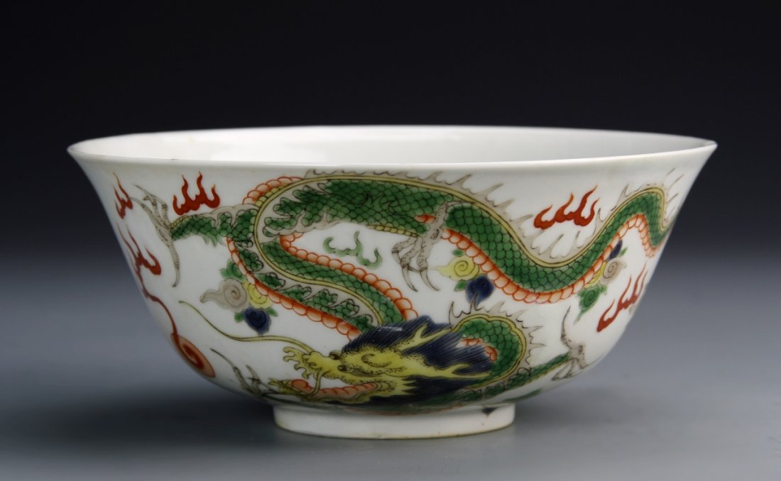 Chinese Wucai Dragon Bowl: China, Yongzheng Period, Wucai dragon bowl, painted with pair leaping dragons each chasing a flaming pearl, with a bouquet of flowers inside the bowl, base with six-character Yongzheng mark. Diameter 