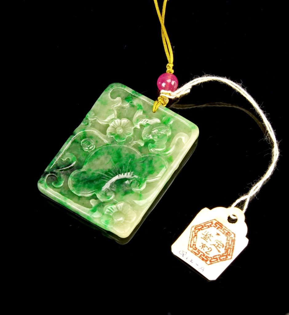 Chinese Emerald Green Jadeite Pendant: China, emerald green jadeite pendant, rectangular form carved with lotus and plum blossoms on one side and coins on the reverse. Length 2 1/4 in. Provenance: Estate of Mrs Lillian Y. Lee, Annapolis, M