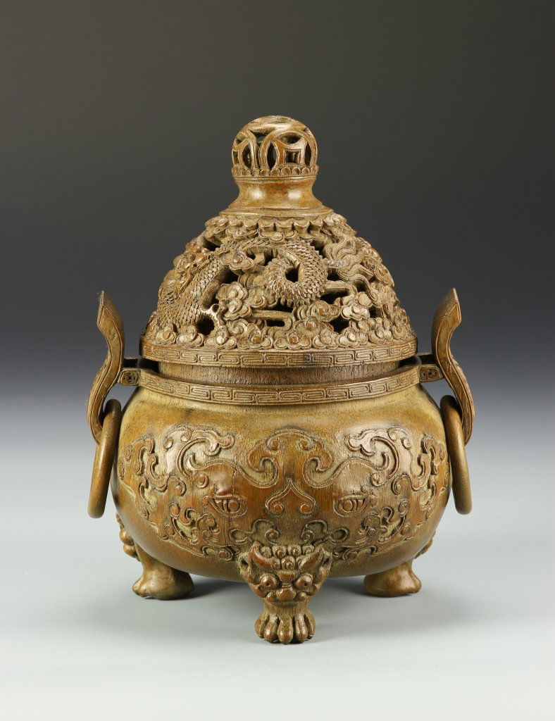 Chinese Bamboo Censer: China, bamboo censer, with tripod footed base, carved attached ring handles, intricate carvings across the surface, open work detail on the cover, and natural wood grain showing. Height 9 3/4 in.