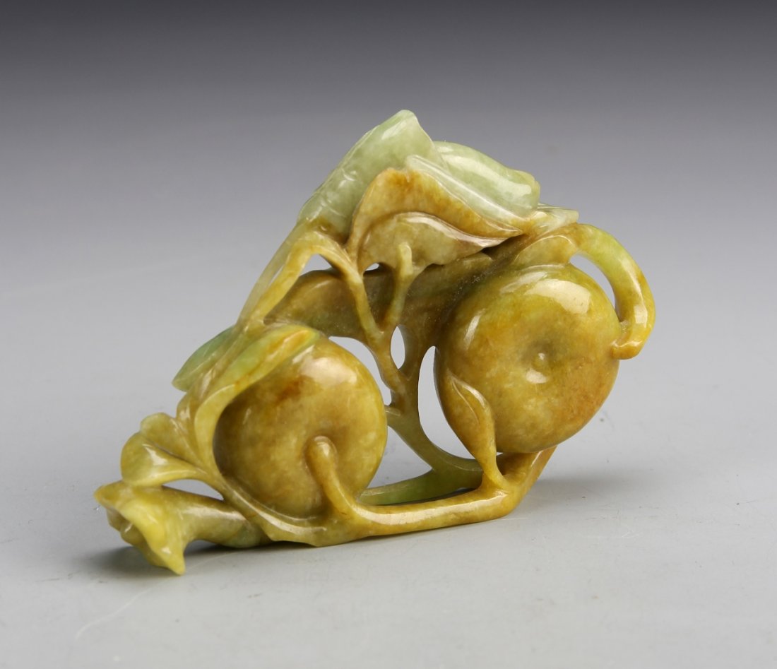 Chinese Jade Ornament: China, jade ornament, in th form of a entangled foliage design, carved cutouts, orange hue on front side, fading green hue on back. Height 3 1/4 in.