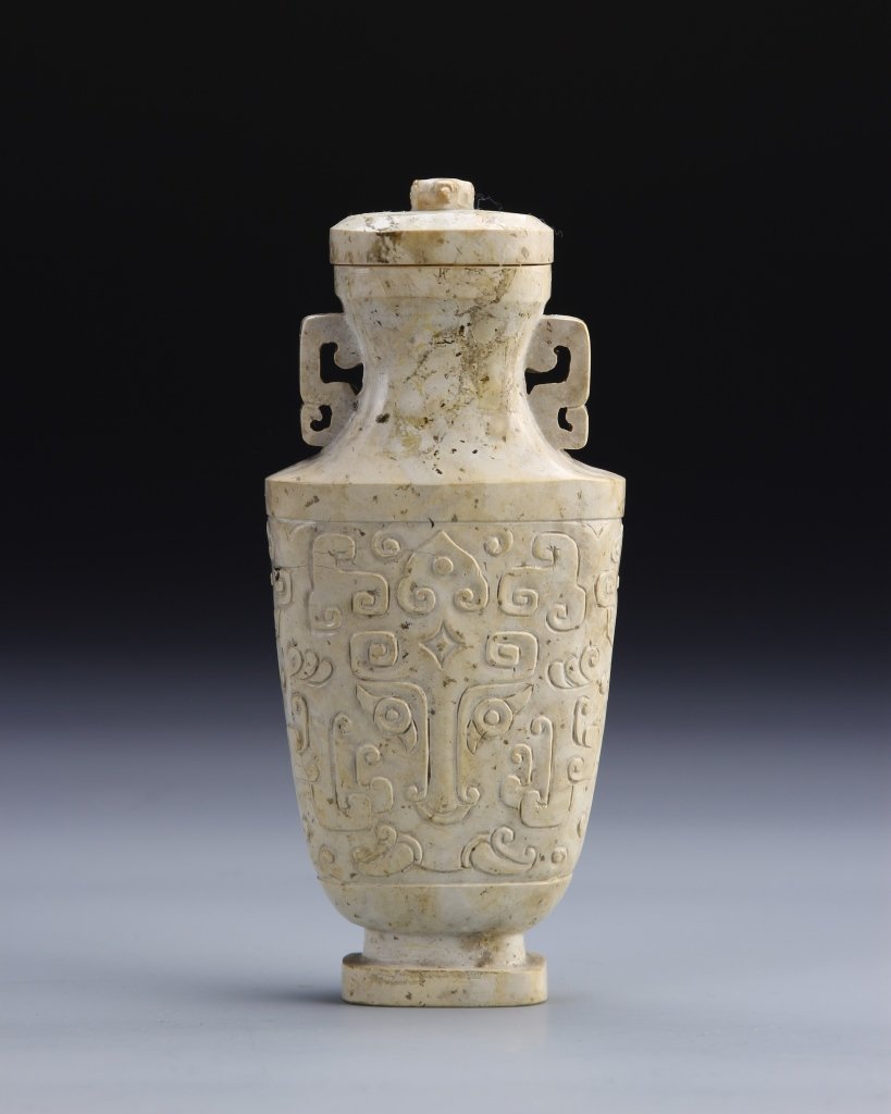 Chinese Covered Stone Vase: China, 19th C., carved stone vase with cover, raised base, with wide shoulder, narrow neck and flared rim, key fret handles attached to neck. Height 6 in.