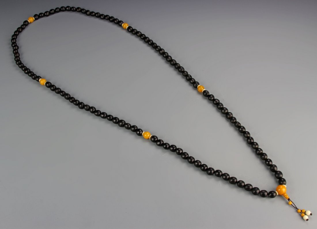 Chinese Zitan Buddhist Prayer Beads: China, Buddhist prayer beads, composed of 108 Zitan beads each carved to simulate a Bodhi seed, spaced with amber honey wax beads. Length 63 in.