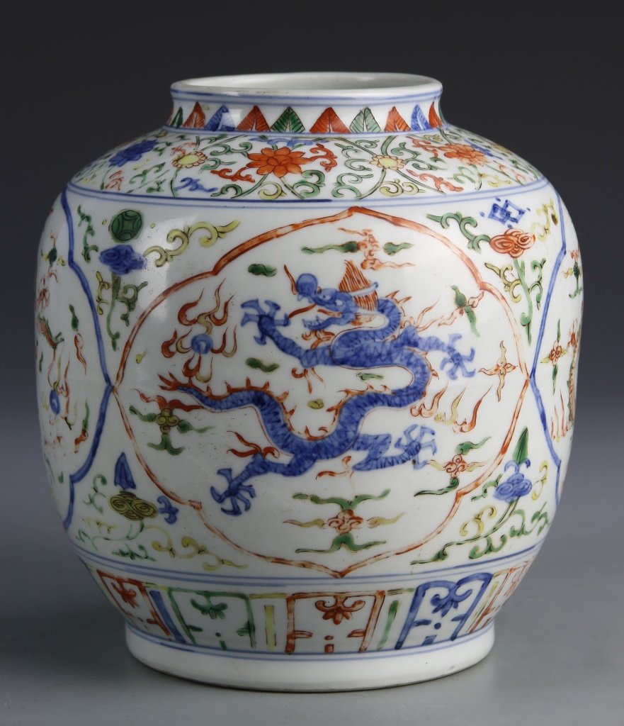 Chinese Wucai Jar: China, Wucai jar, rounded form with short neck, densely decorated with floral motifs and central medallions showing blue serpentine dragons, Jiaqin Mark on base. Height 9 in.