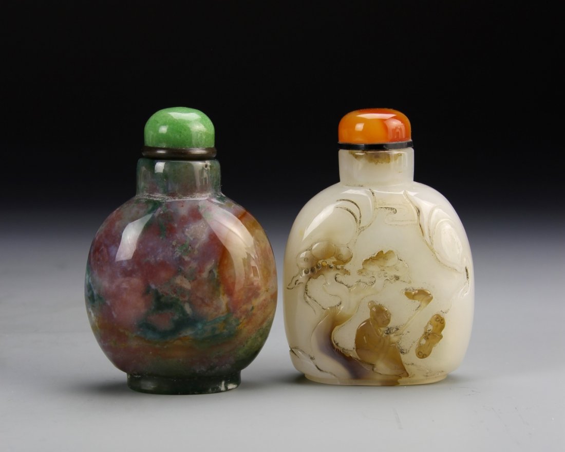 Chinese Agate Snuff Bottles: China, 19th C., agate snuff bottles, one bottle in a rounded form, the other in a square form with rounded shoulders, one green and one coral stopper. Height 3 in.