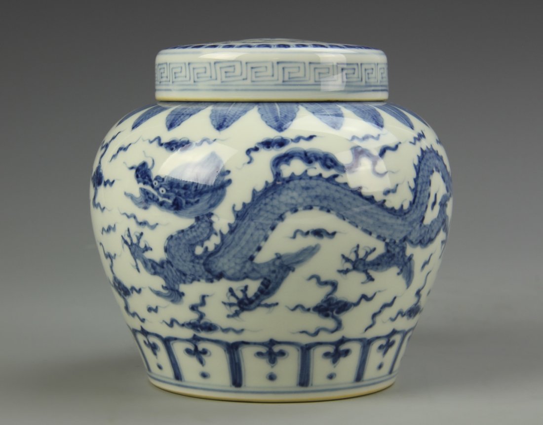 Chinese Blue and White Jar: China, blue and white jar, with scrolling dragon and cloud motifs, pedal lappets at the neck and base, and key-fret, with cover, mark on base. Height 4 1/2 in.
