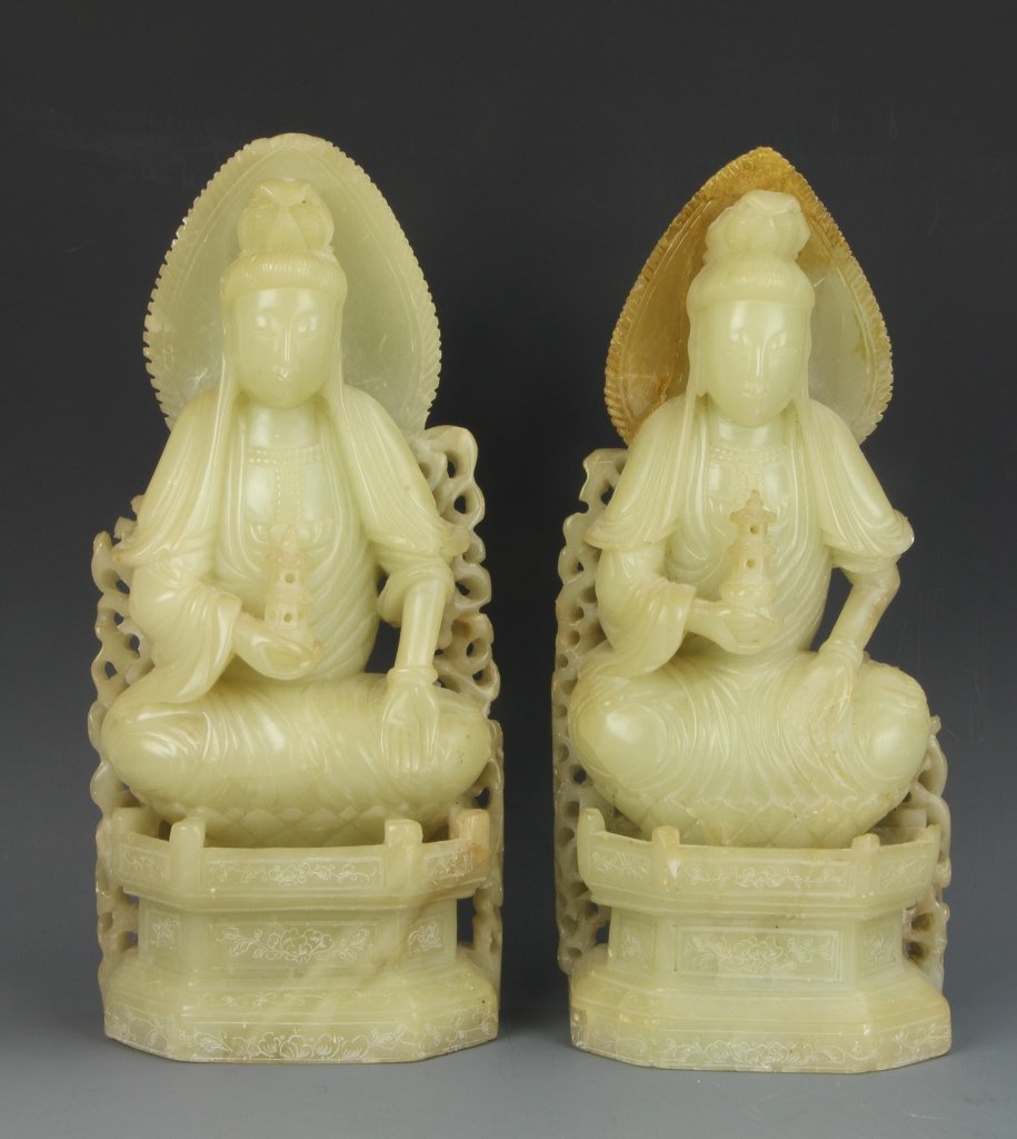 Pair of Chinese Soap Stone Guanyin: China, pair of soap stone Guanyin, both in crossed leg seat positions, in elaborated attached chairs, white hue, with some orange coloring at the top of one chair, minor damage. Height 11 1/4 in.