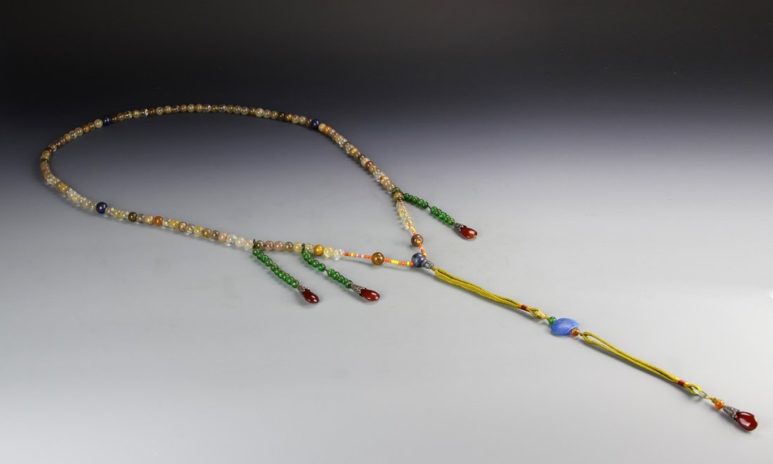 Chinese Crystal Court Necklace: China, crystal court necklace, with lapis and agate beads strung into an ornate structure including various colors and extensions with clawed settings and tassels. Length 48 in.