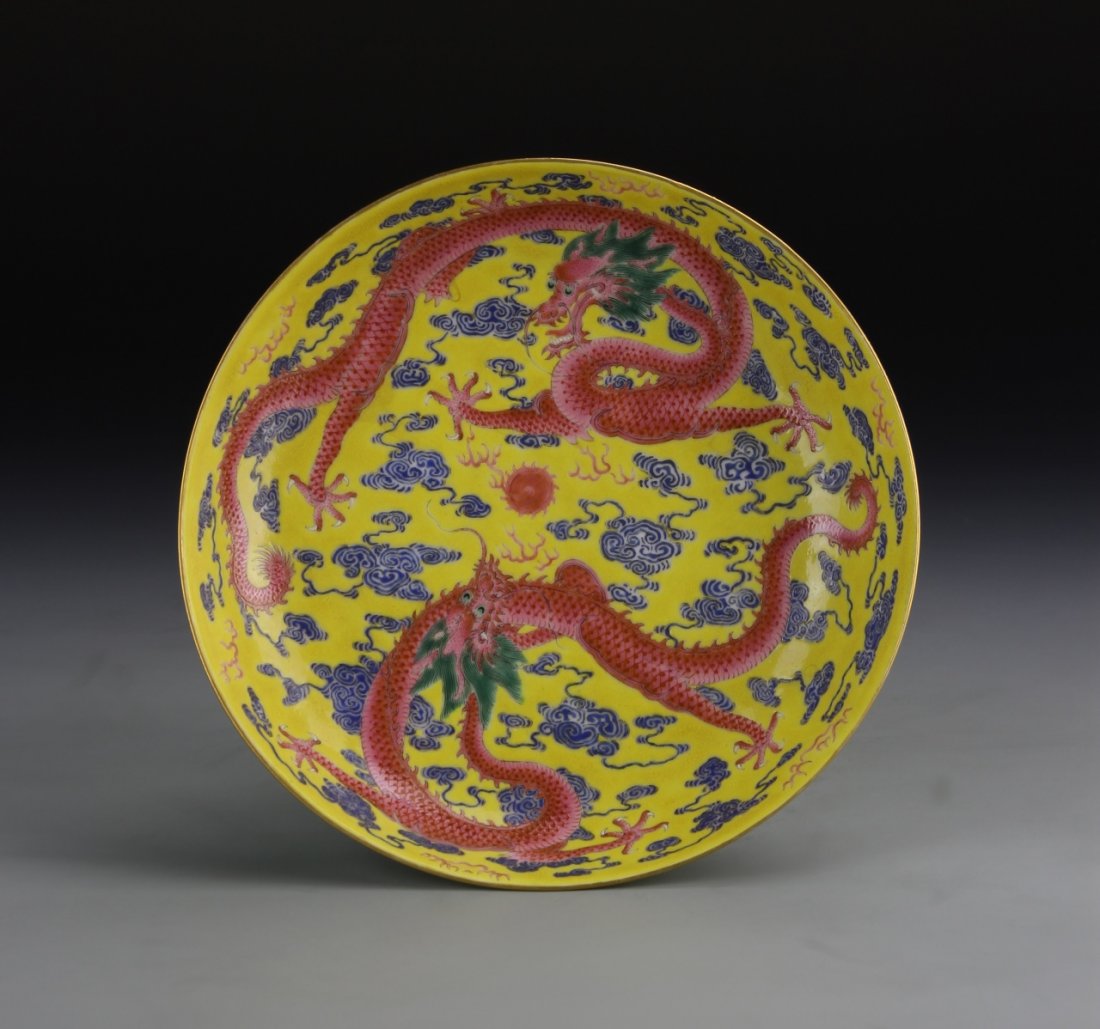 Chinese Famille Rose Plate: China, Early 20th C., Famille Rose plate featuring two red dragons among dark blue swirling clouds over a yellow ground, Xuantong mark. Diameter 6 7/8 in.