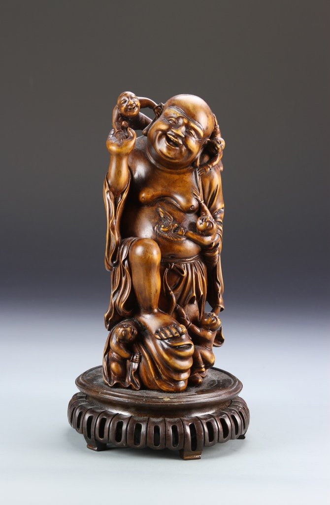 Chinese Boxwood Statue: China, 19th C., boxwood statue, with a figure in a standing position, with two other small figures at his feet, carved base, and natural wood grain showing. Height 10 1/4 in.