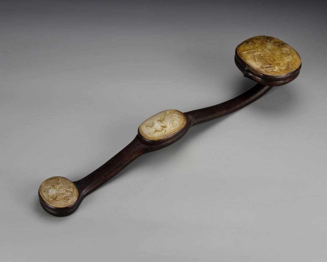 Chinese Jade and Wood Ruyi Scepter: China, 19th C., jade and wood ruyi scepter, smoothly carved wooden staff with jade panels inlaid at the base, middle, and head, featuring a man on a horse. Length 19 in.